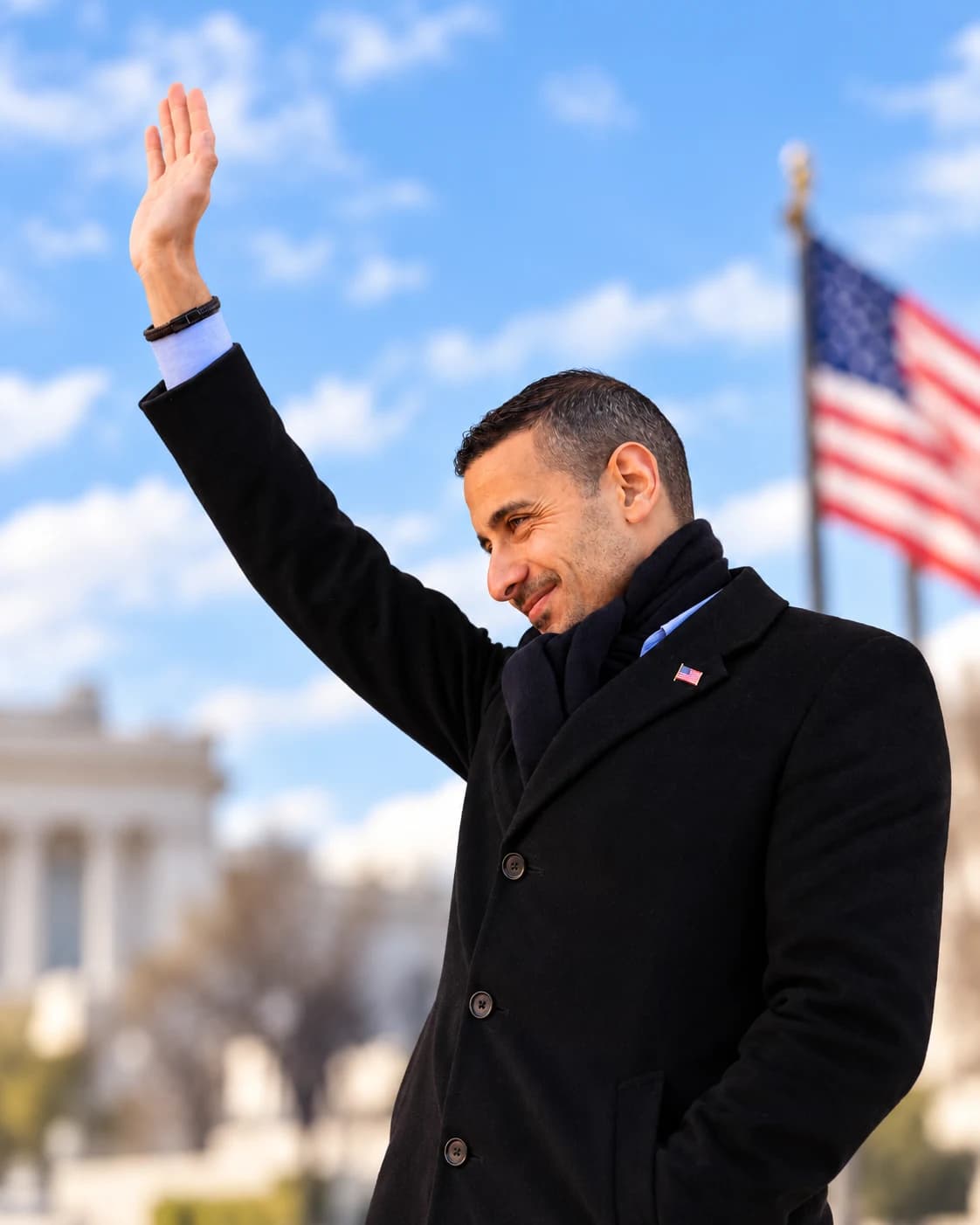 Councilman Abdel Elnoubi waves in front of an American flag.